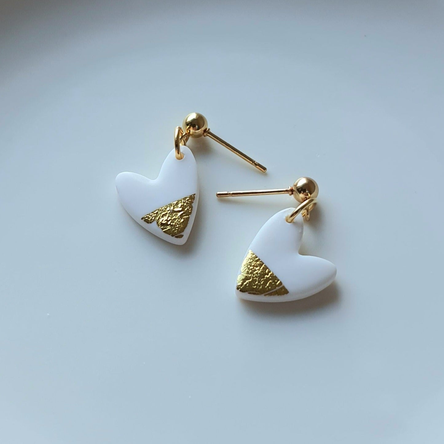 White hearts with golden flakes dangle earrings