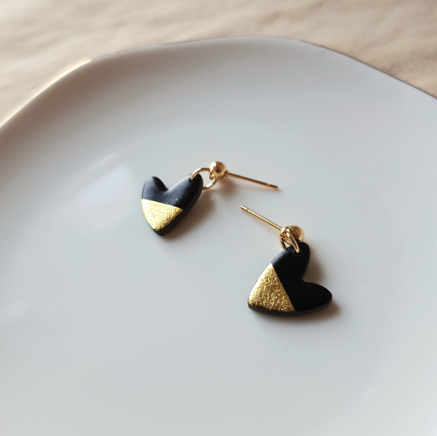 Black hearts with golden flakes dangle earrings