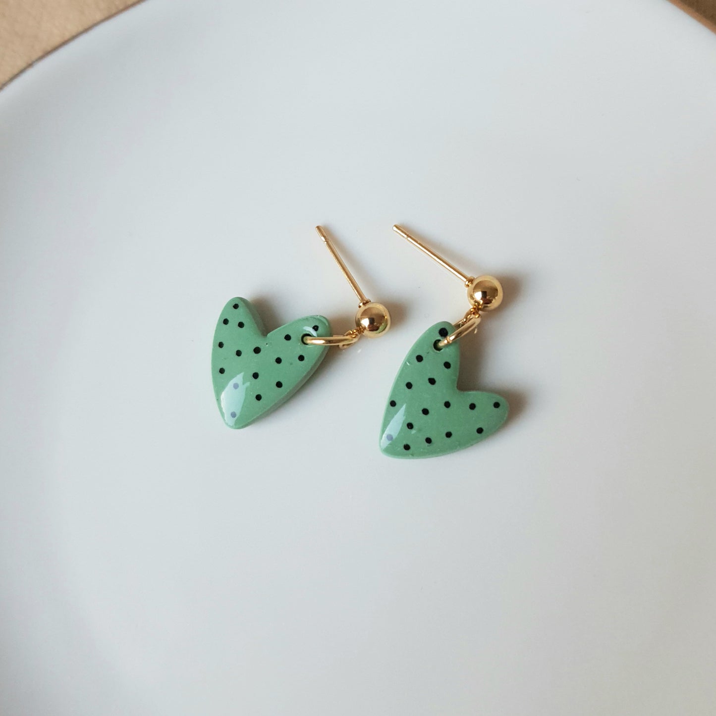 Green spotted dangly heart earrings