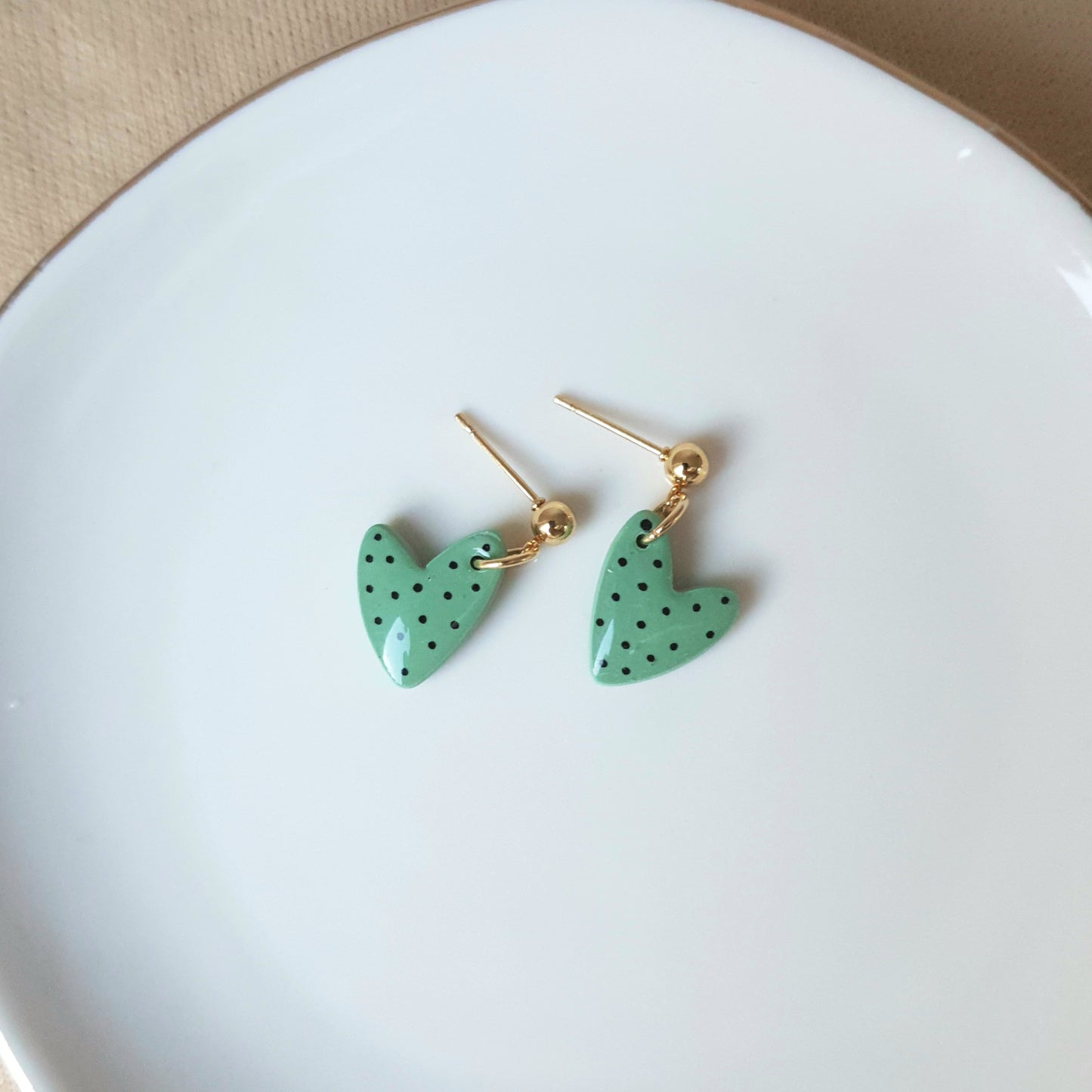 Green spotted dangly heart earrings
