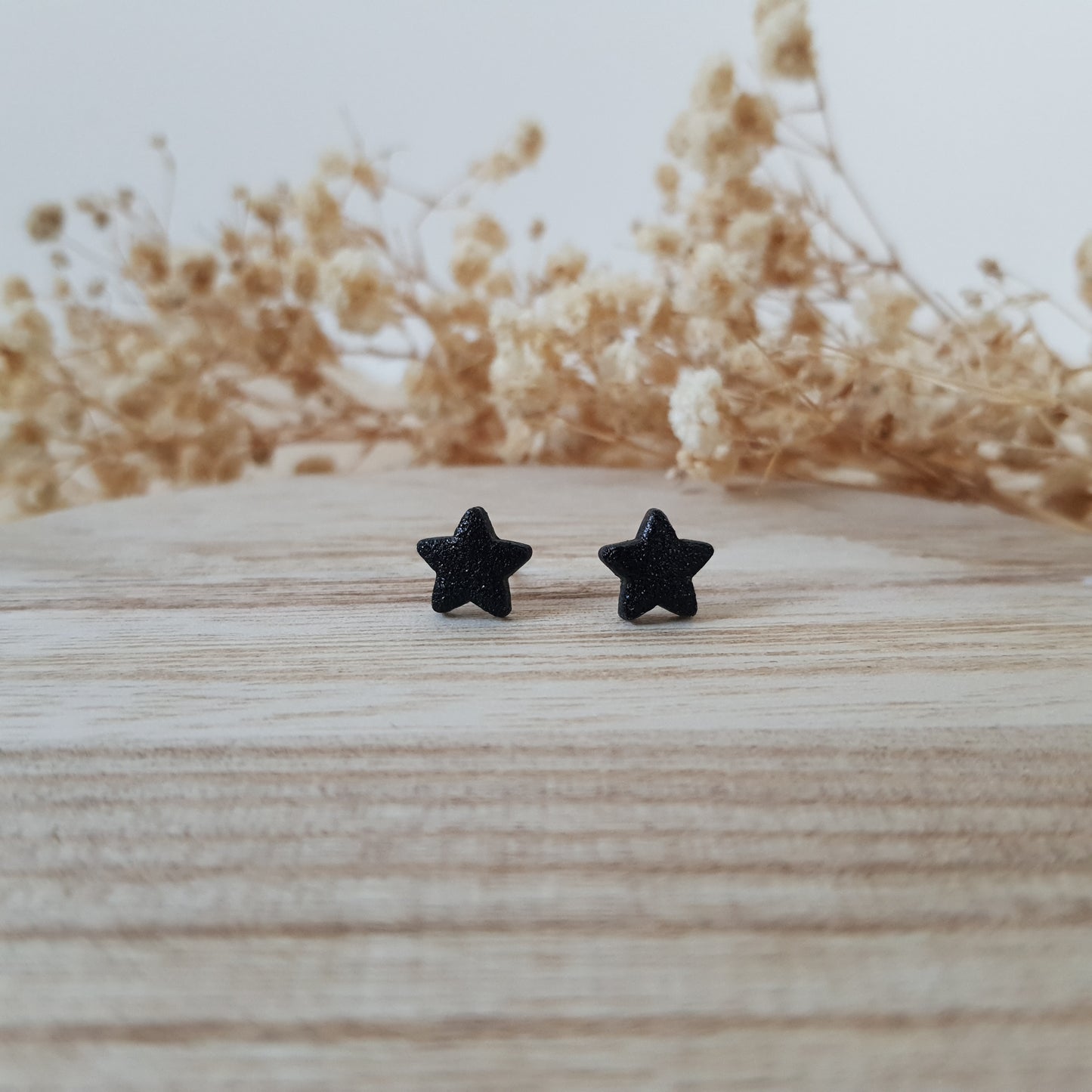 Black textured star earrings
