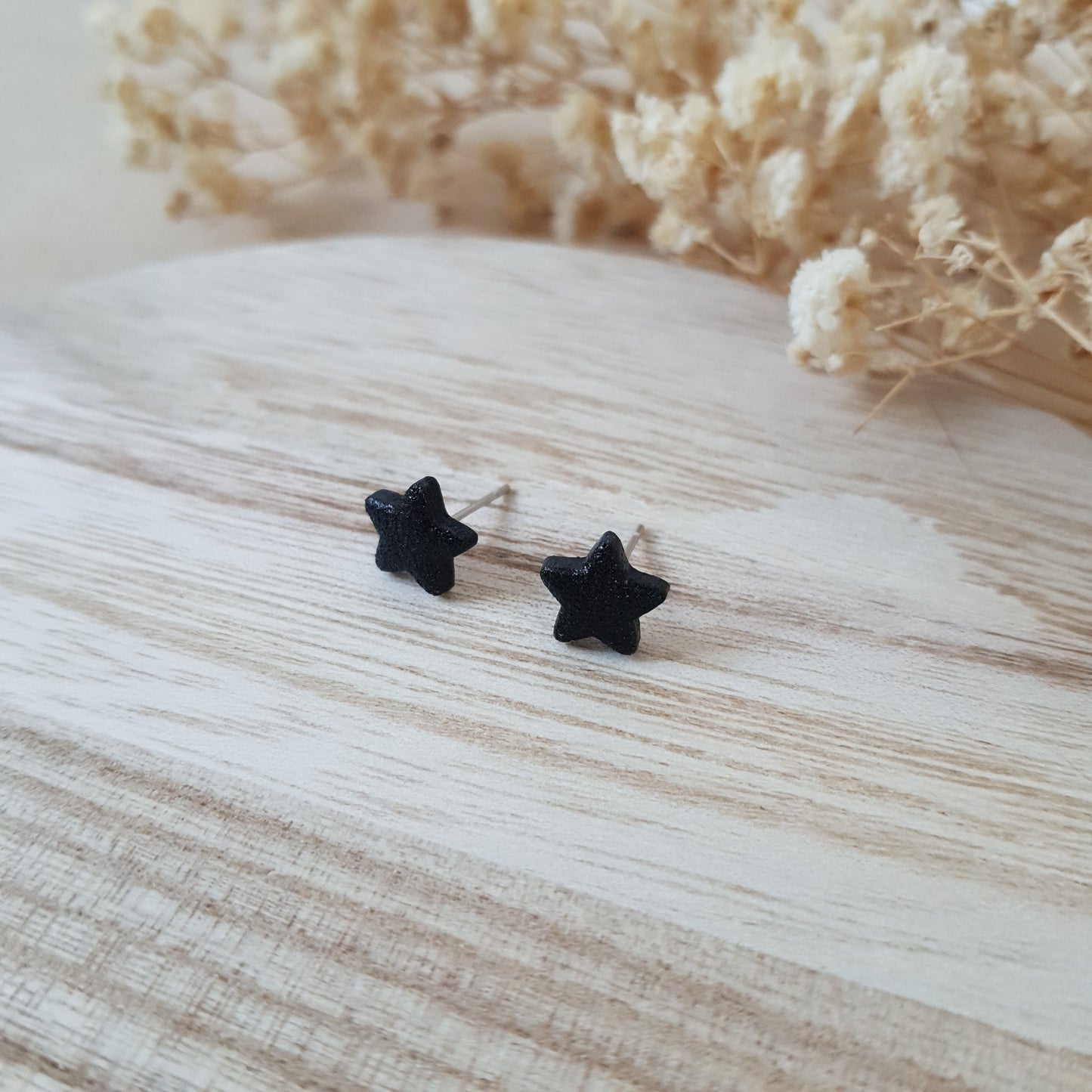 Black textured star earrings