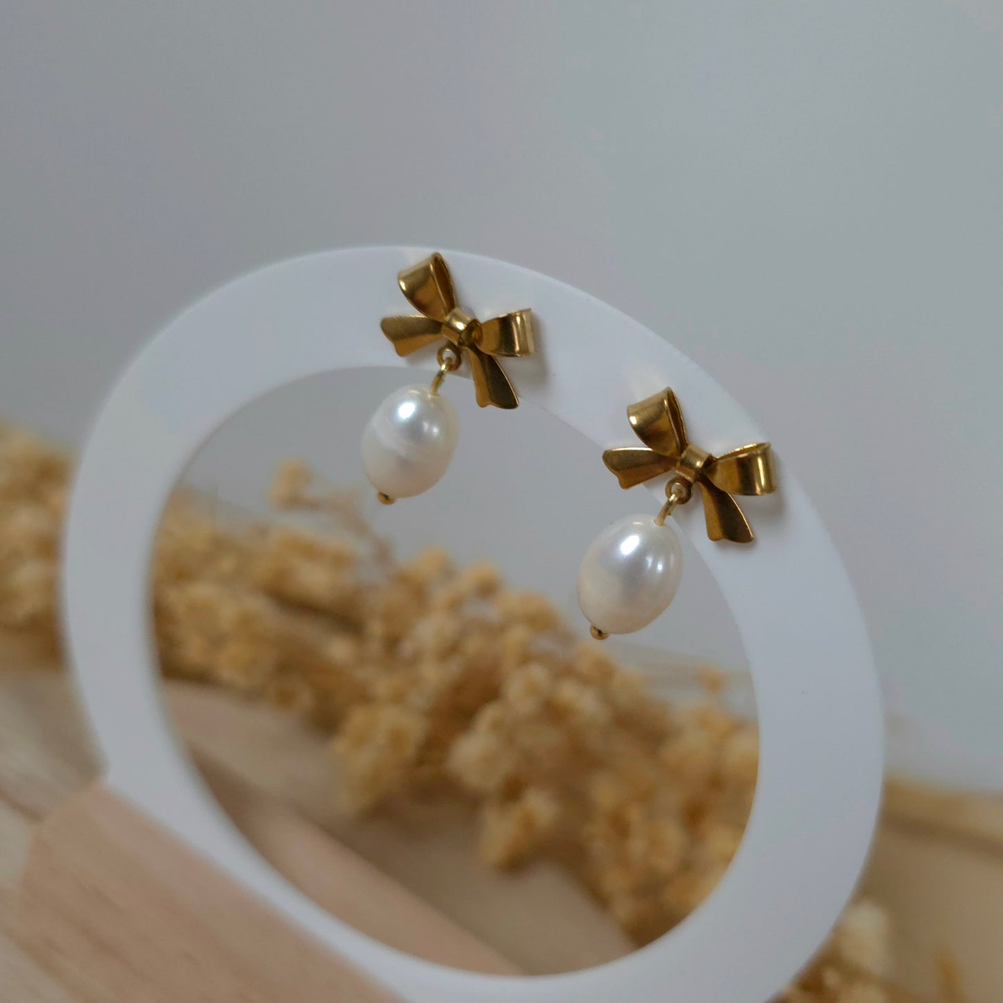 Golden bow and pearl earrings