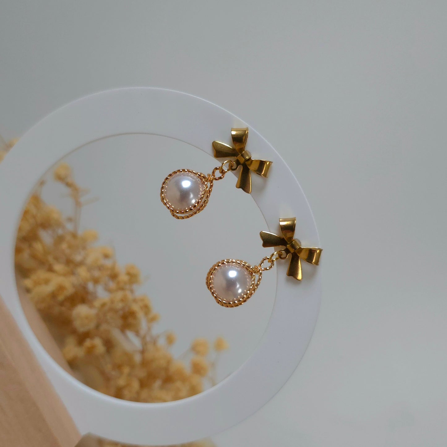 Golden bow and faux pearl earrings