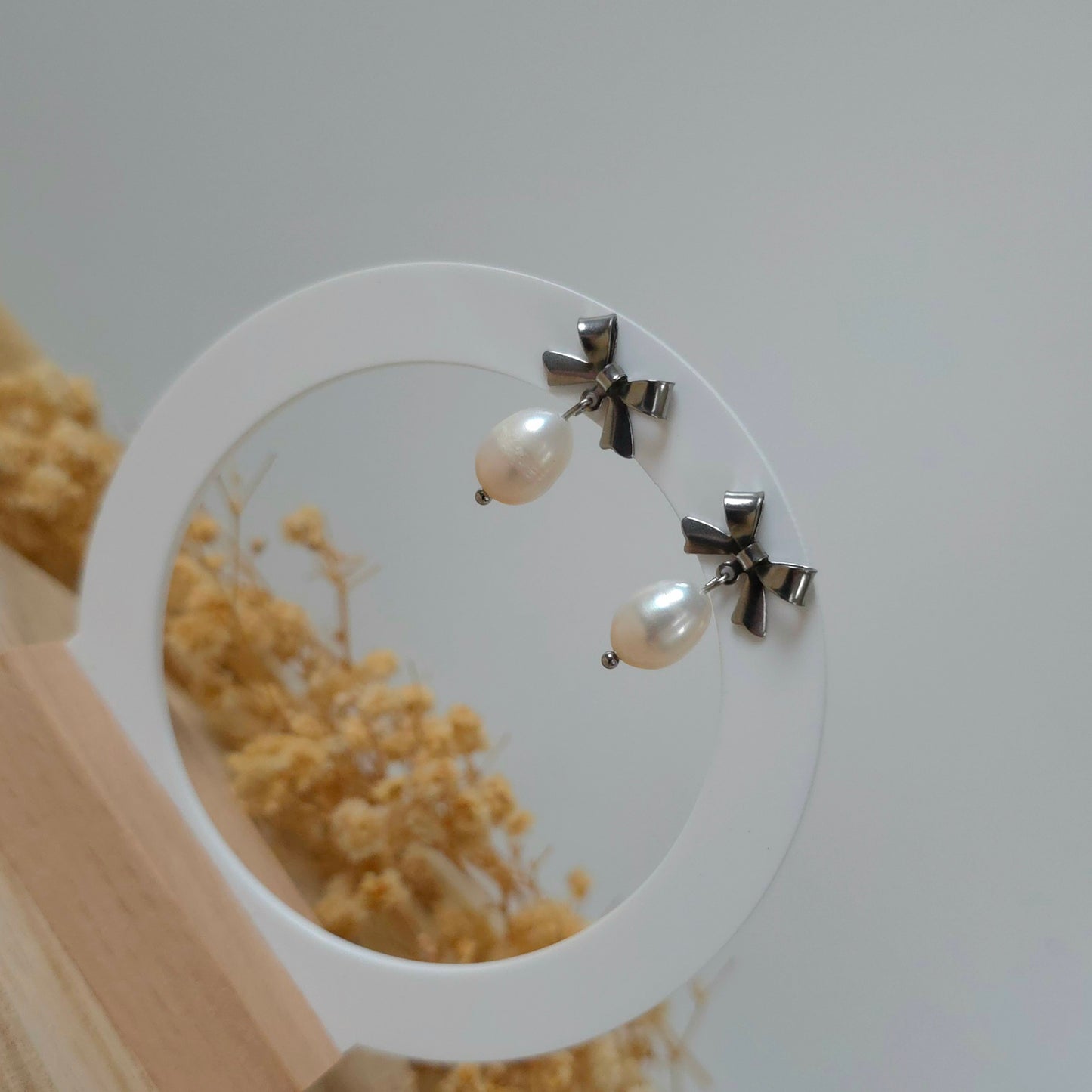 Silver bow and pearl earrings