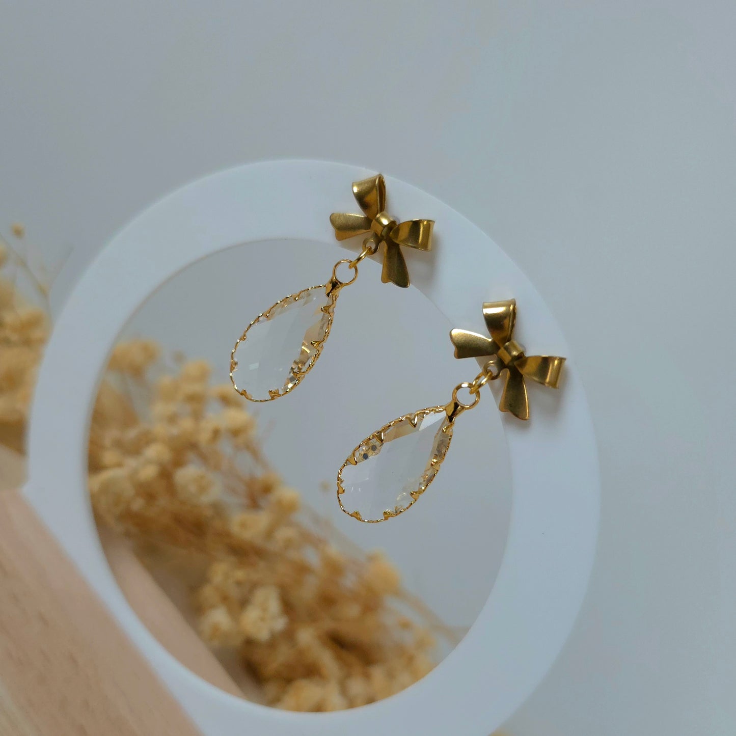Gold and crystal bow dangle earrings