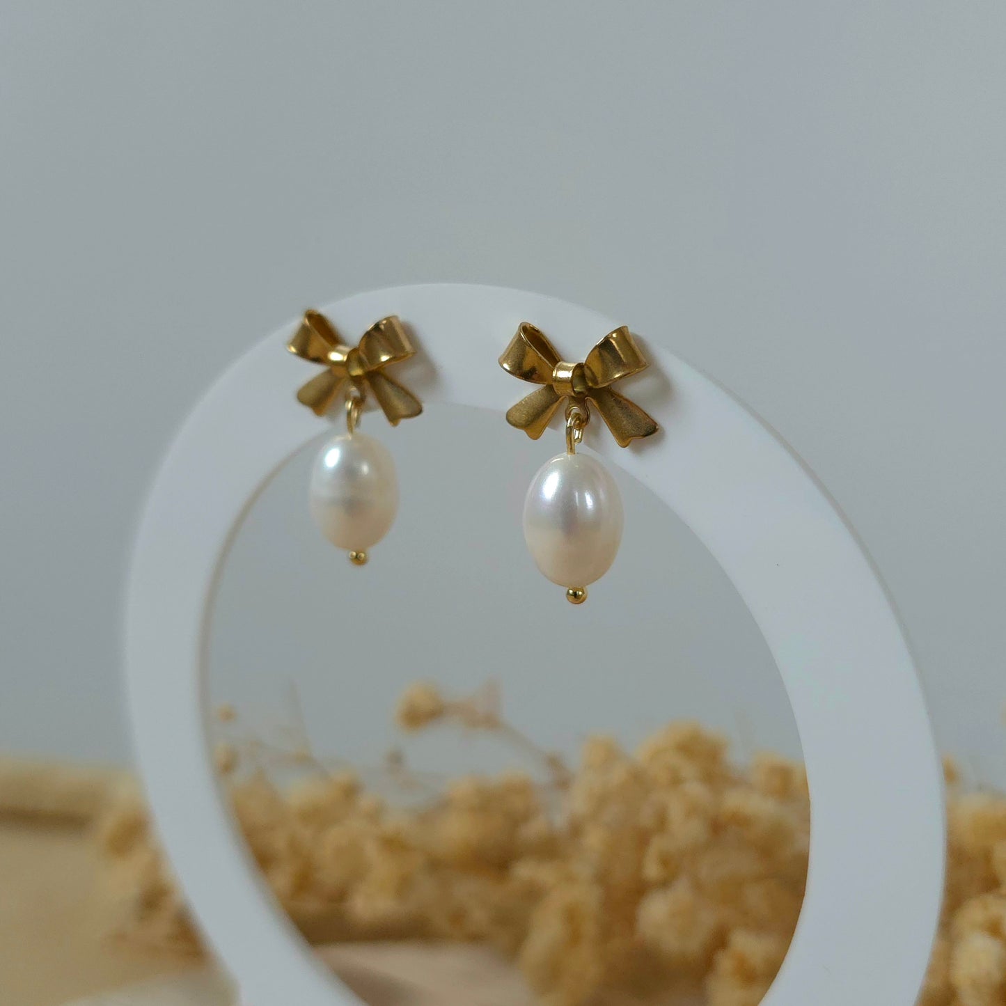Golden bow and pearl earrings
