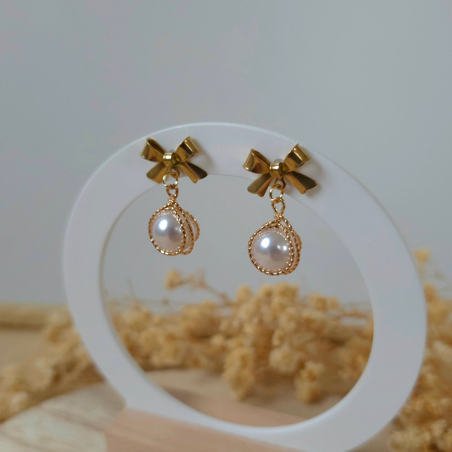 Golden bow and faux pearl earrings