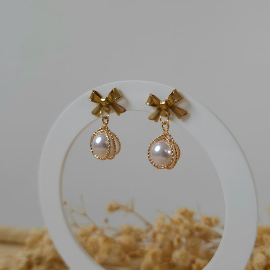 Golden bow and faux pearl earrings