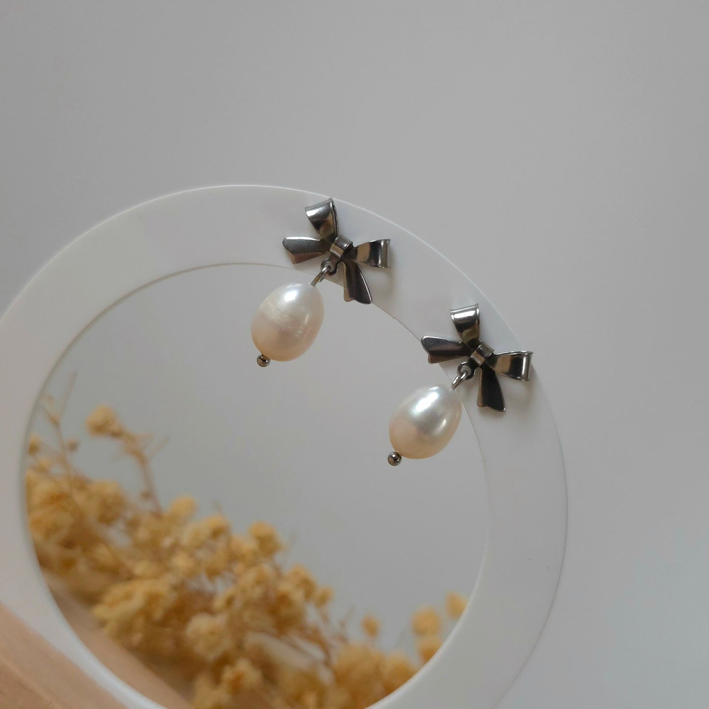 Silver bow and pearl earrings